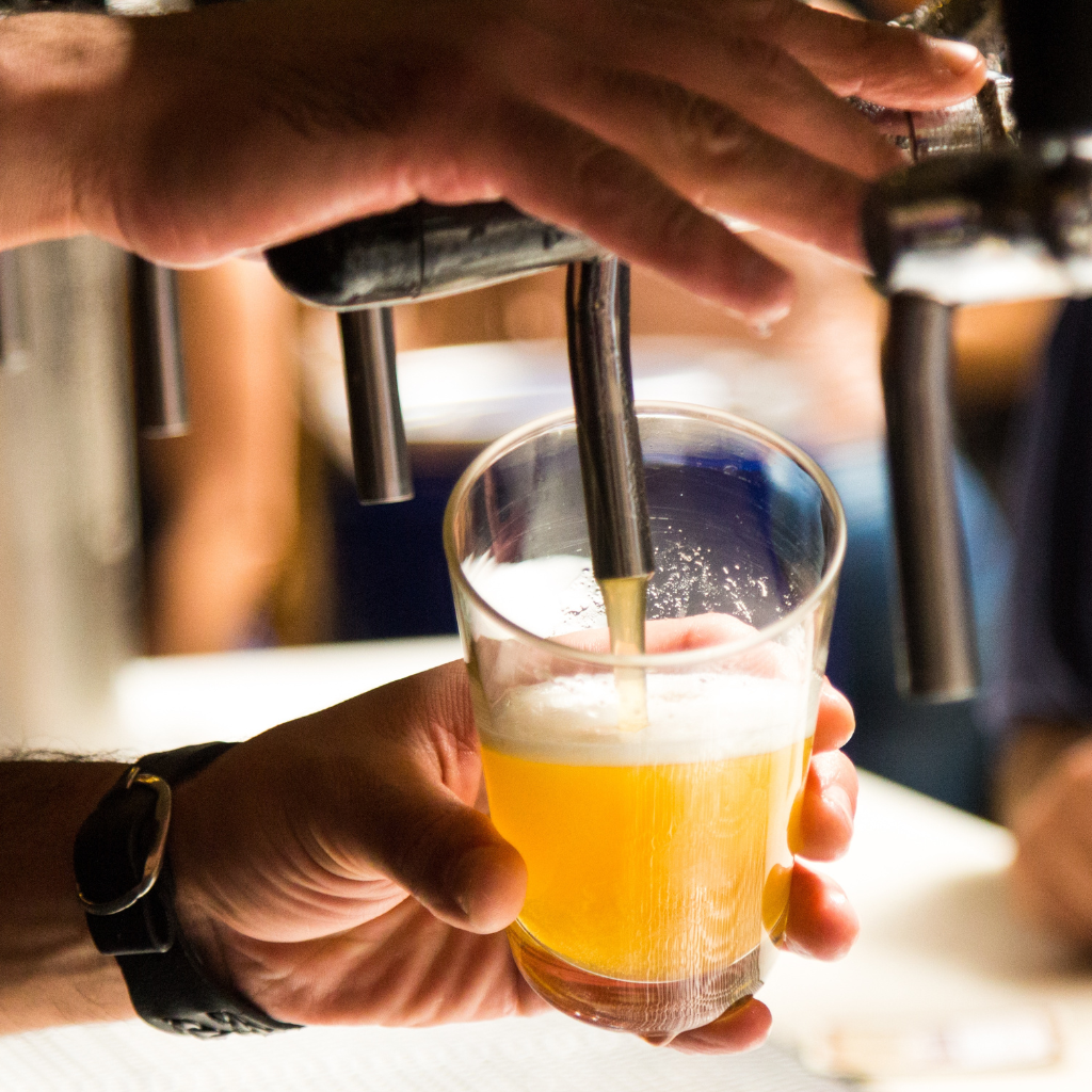 gros plan sur les mains d'un serveur qui tire une bière pression à la pompe à bière