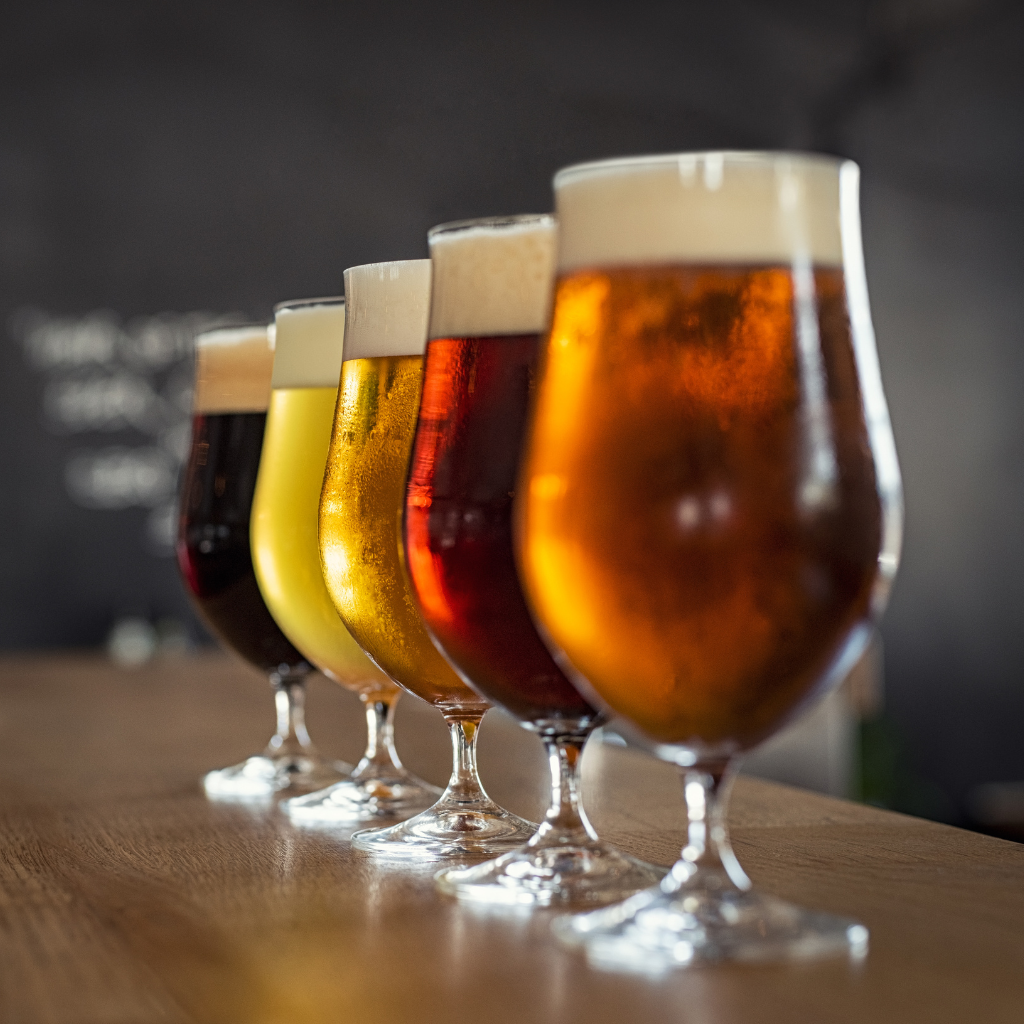 Bières blonde, ambrée et rouge alignées sur le comptoir d'un bar
