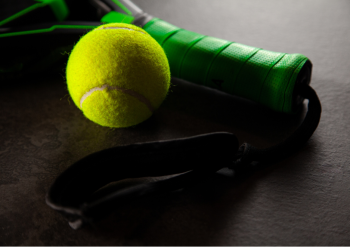 gros plan sur une balle et un manche de raquette de Padel vert.